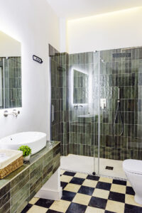 Cuarto de baño de diseño en planta segunda de NintaiHome, con acabados en verde y equipamiento de alta calidad.