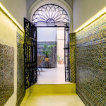 Entrada histórica con azulejos tradicionales en NintaiHome Los Venerables, un reflejo del encanto auténtico de Sevilla en el barrio de Santa Cruz.