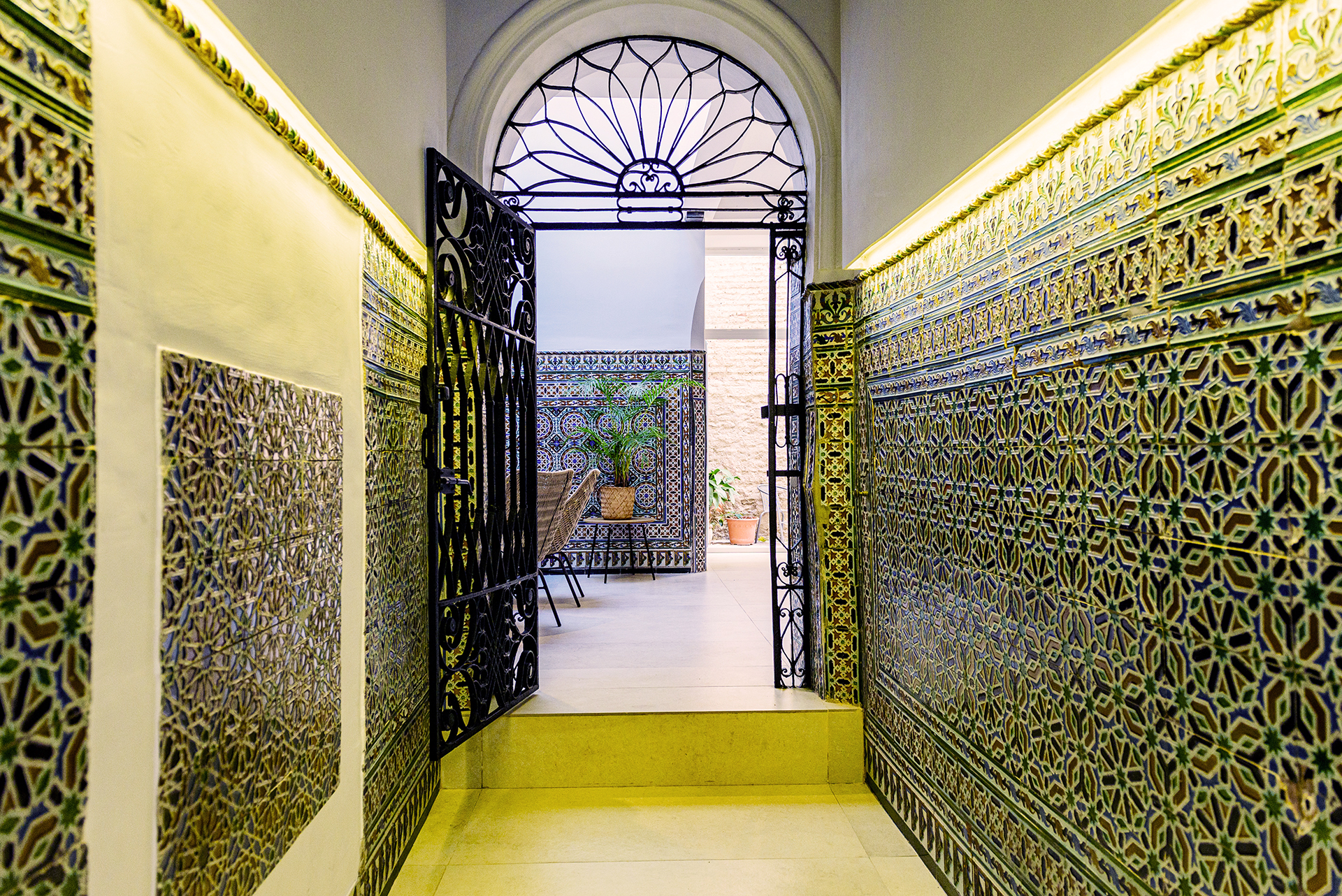 Entrada histórica con azulejos tradicionales en NintaiHome Los Venerables, un reflejo del encanto auténtico de Sevilla en el barrio de Santa Cruz.