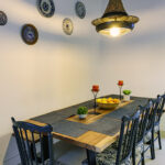 Mesa de comedor de madera con sillas y banco en NintaiHome Los Venerables, un espacio diseñado para compartir momentos memorables en el corazón de Sevilla.
