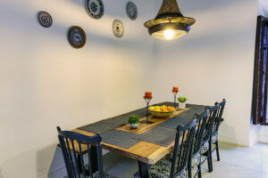 Mesa de comedor de madera con sillas y banco en NintaiHome Los Venerables, un espacio diseñado para compartir momentos memorables en el corazón de Sevilla.