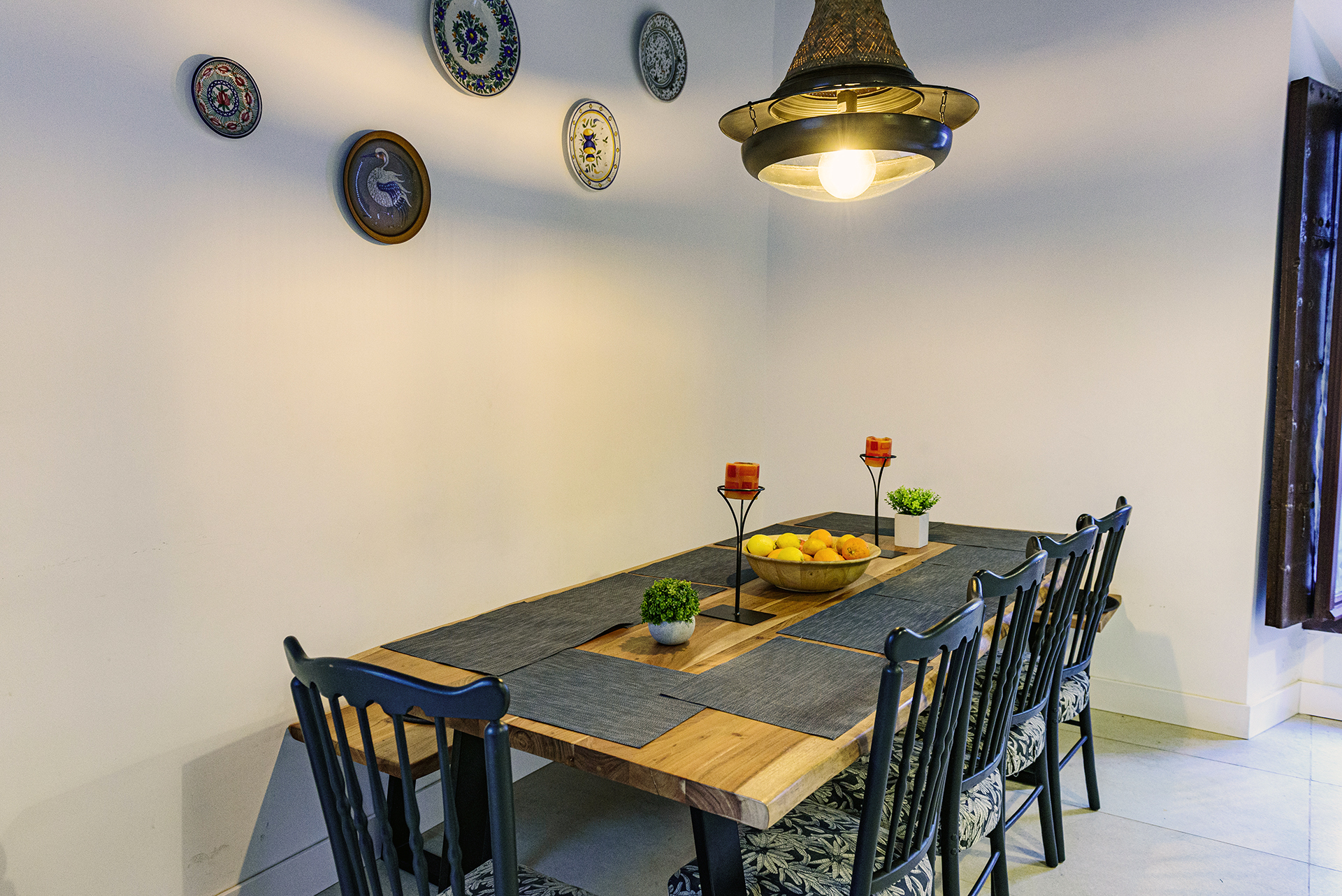 Mesa de comedor de madera con sillas y banco en NintaiHome Los Venerables, un espacio diseñado para compartir momentos memorables en el corazón de Sevilla.