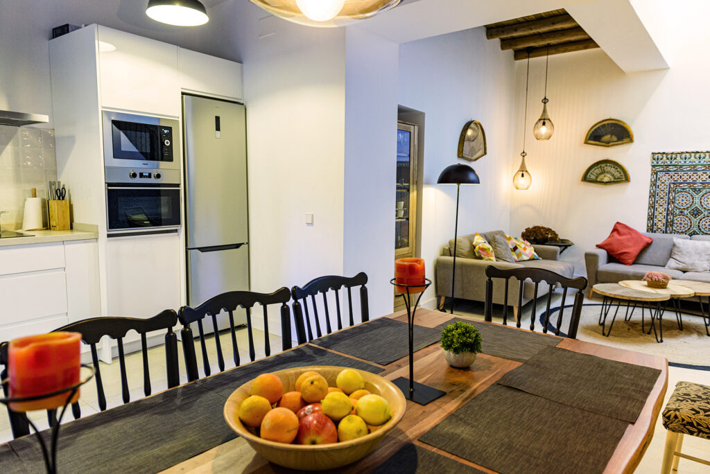 Tu hogar de paz en el barrio de Santa Cruz Vista del salón principal desde el comedor en NintaiHome Los Venerables, destacando la fluidez del espacio abierto y una decoración que invita al bienestar.