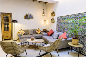Vista del salón de NintaiHome con pared de azulejos originales y decoración cuidada para un ambiente de paz y equilibrio.