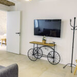 Acogedor salón en la planta alta de NintaiHome en Sevilla, equipado con sofá confortable y televisión para el descanso de nuestros huéspedes.