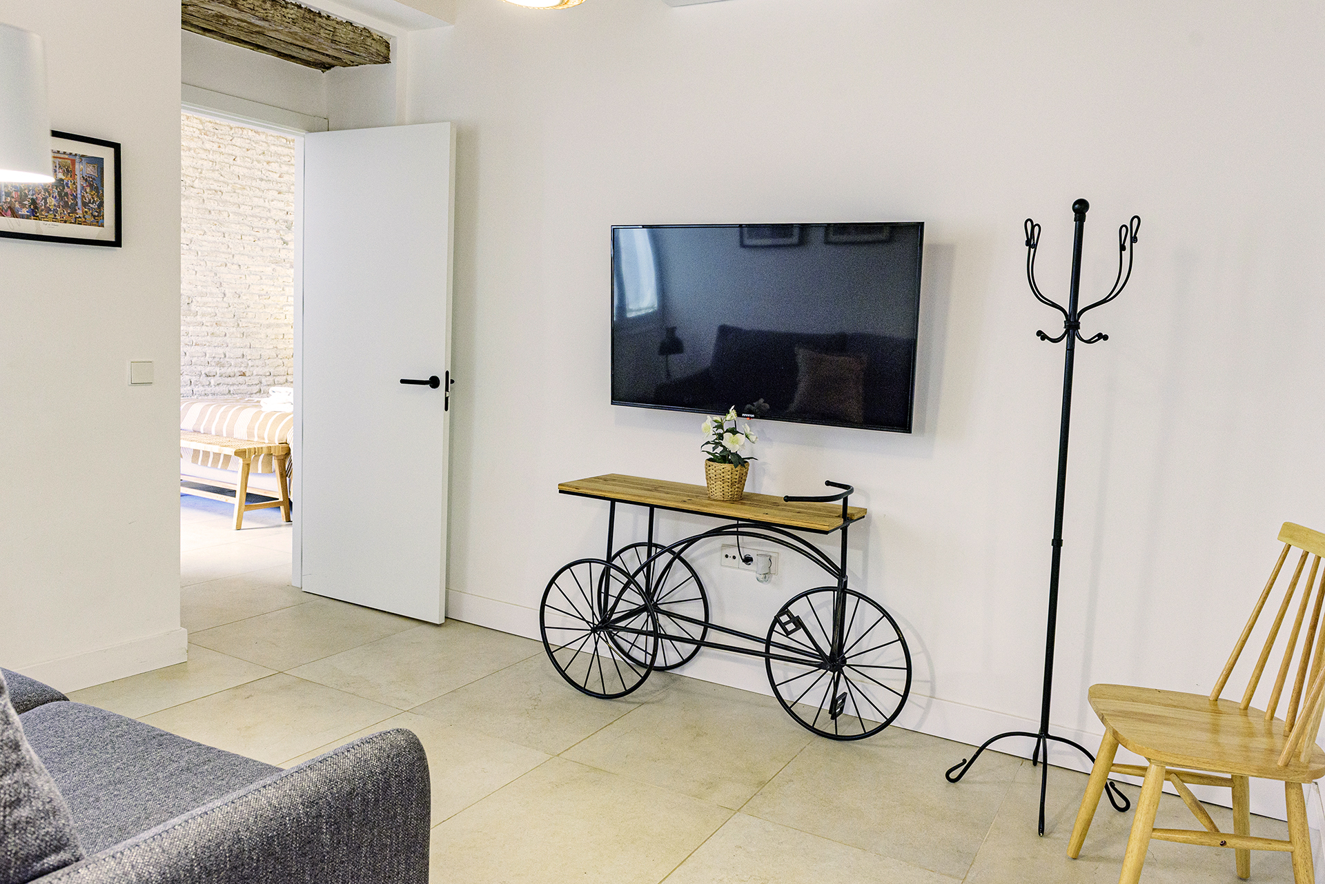 Acogedor salón en la planta alta de NintaiHome en Sevilla, equipado con sofá confortable y televisión para el descanso de nuestros huéspedes.