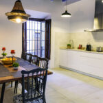 Cocina totalmente equipada y amplia mesa de madera en el comedor de NintaiHome Los Venerables, un espacio acogedor para compartir momentos inolvidables.