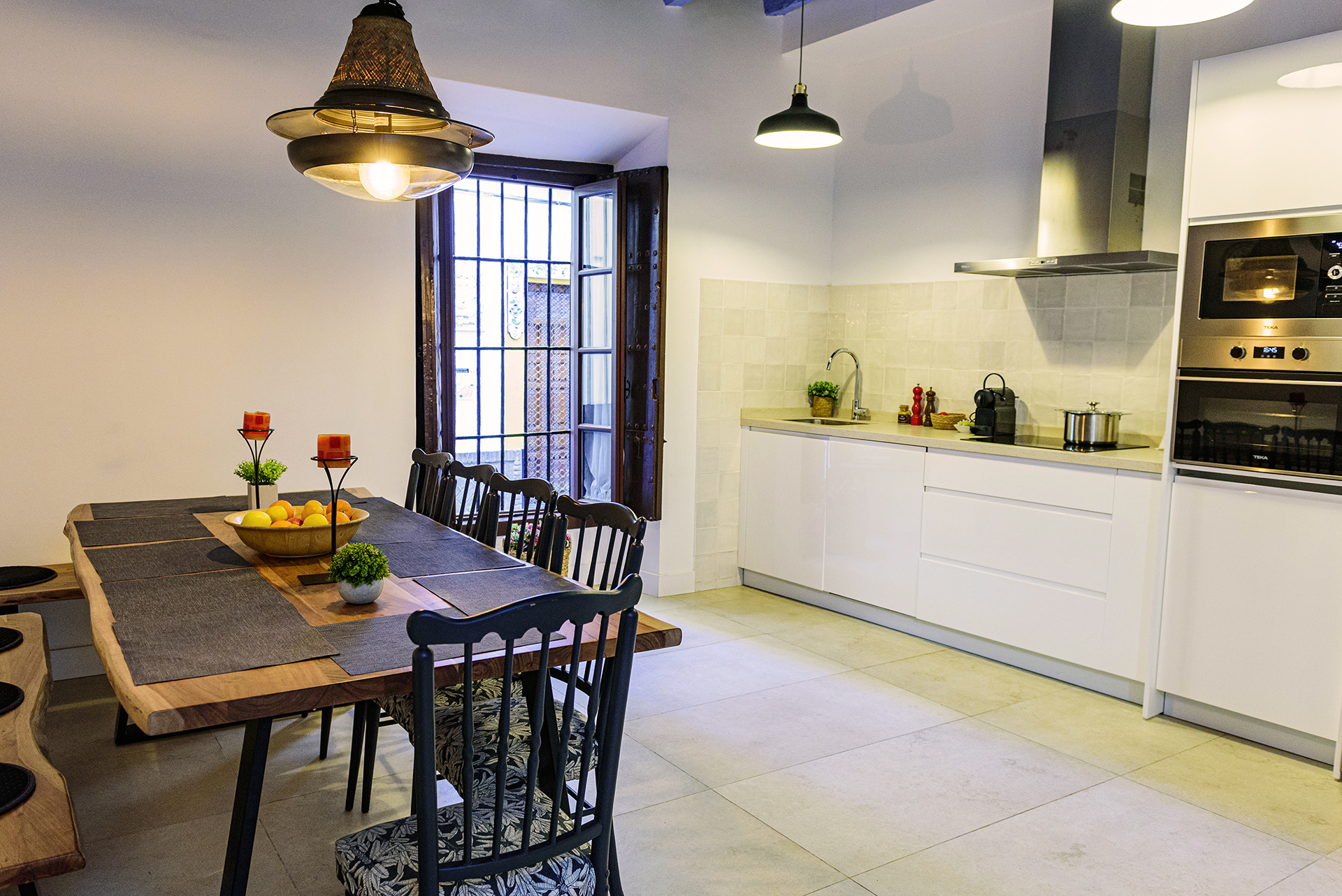 Cocina totalmente equipada y amplia mesa de madera en el comedor de NintaiHome Los Venerables, un espacio acogedor para compartir momentos inolvidables.